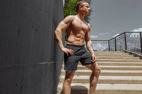 Fitness modell man stående skjorta mot grå bakgrund utomhus — Stockfoto