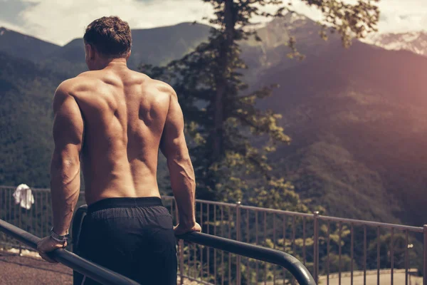 Hombre musculoso durante su entrenamiento al aire libre en las montañas. — Foto de Stock