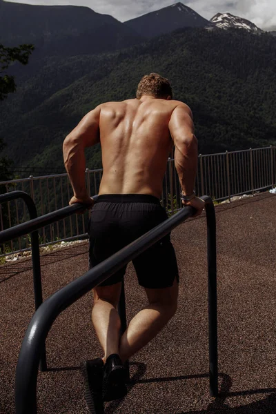 Homem musculoso durante seu treino ao ar livre nas montanhas . — Fotografia de Stock