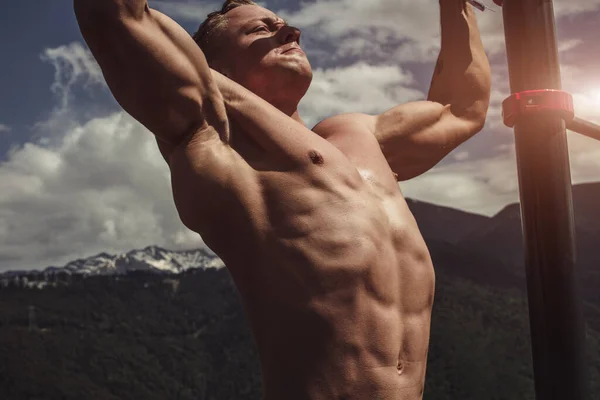 Homem musculoso durante seu treino ao ar livre nas montanhas . — Fotografia de Stock