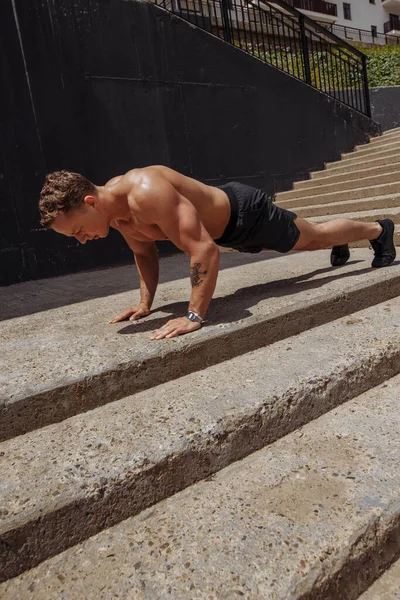 Sportsman träning push up motion utomhus i trappan — Stockfoto