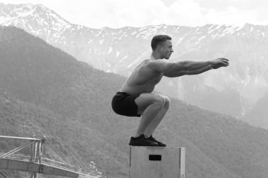 Erkek atlamacı patlayıcı güç sıçraması yapıyor, uygun spor yapıyor.