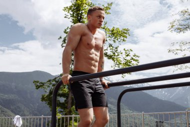 Motivasyonlu sporcu vücut ağırlığı yapar. Dağlık alanda açık spor salonunda şınav çeker..