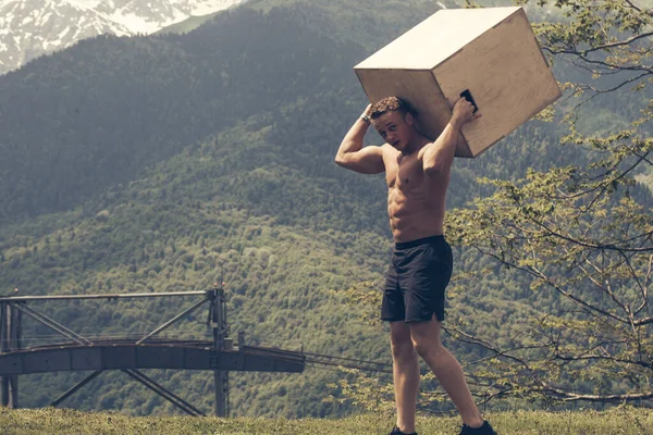 Atlético homem se preparando para caixa de salto crossfit exercício ao ar livre em montanhas — Fotografia de Stock