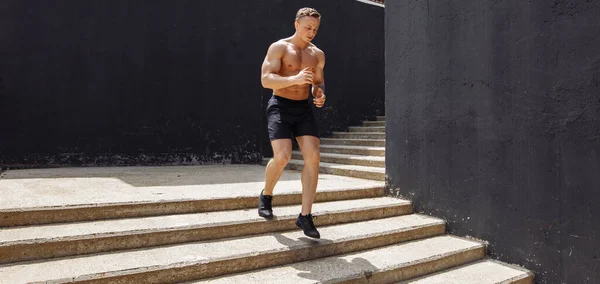 Sin camisa corredor masculino guapo en las escaleras sobre fondo urbano —  Fotos de Stock