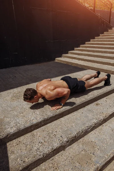 Sportler trainieren Liegestütze im Freien auf der Treppe — Stockfoto