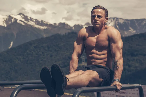 El hombre atlético motivado hace flexiones de peso corporal en el área de las montañas gimnasio al aire libre. — Foto de Stock