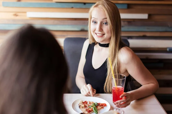 Blondýny žena v elegantních černých šatech pití růžový nápoj v restauraci — Stock fotografie