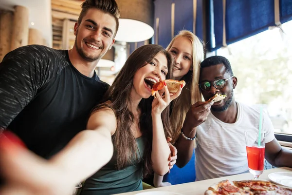 Barátok szelfit csinálnak egy okos telefonon miközben pizzát esznek a bulin.. — Stock Fotó