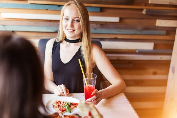 Donna bionda in elegante abito nero bere bevanda rosa al ristorante — Foto Stock