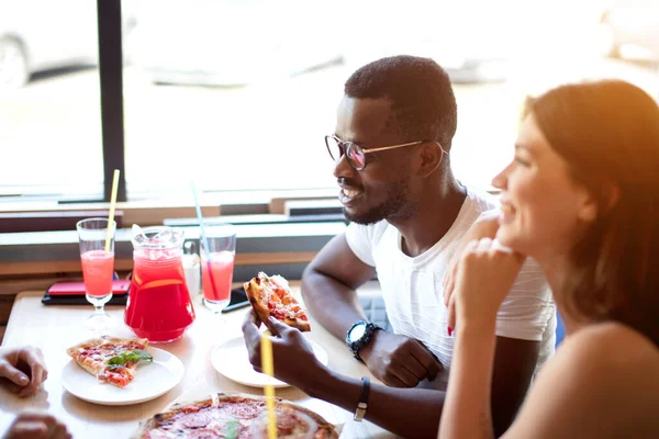 Barátság, étel, ebéd és emberek koncepciója - boldog csapat pizzát eszik a kávézóban — Stock Fotó