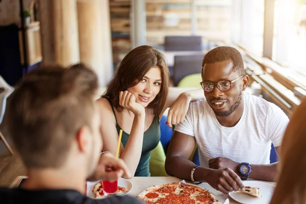 Barátság, étel, ebéd és emberek koncepciója - boldog csapat pizzát eszik a kávézóban — Stock Fotó