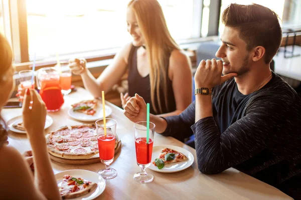 Barátság, étel, ebéd és emberek koncepciója - boldog csapat pizzát eszik a kávézóban — Stock Fotó