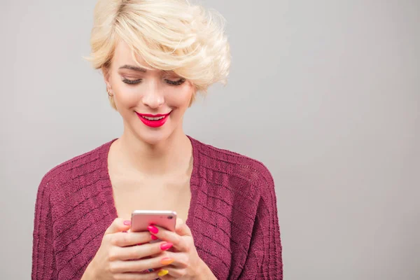 Стильные блондинка молодая женщина звонит смс и с помощью телефона изола — стоковое фото