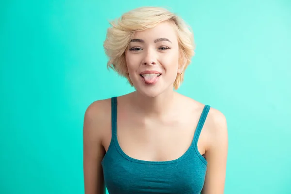 Porträt einer glücklichen blonden Frau mit herausstreckender Zunge — Stockfoto