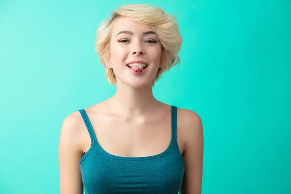 Porträt einer glücklichen blonden Frau mit herausstreckender Zunge — Stockfoto