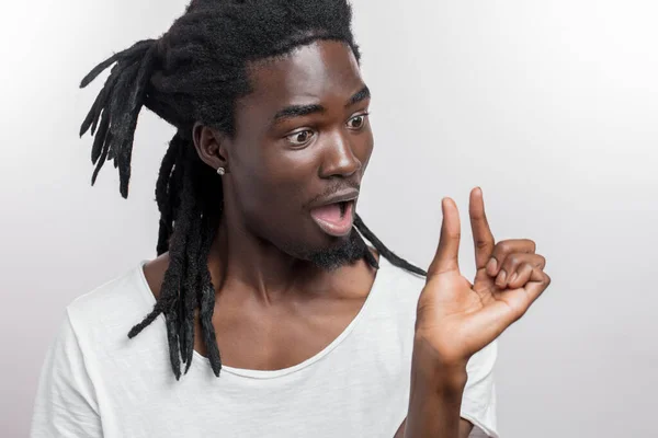 Surpreso macho africano com dreadlocks mostra pequeno sinal com a mão — Fotografia de Stock