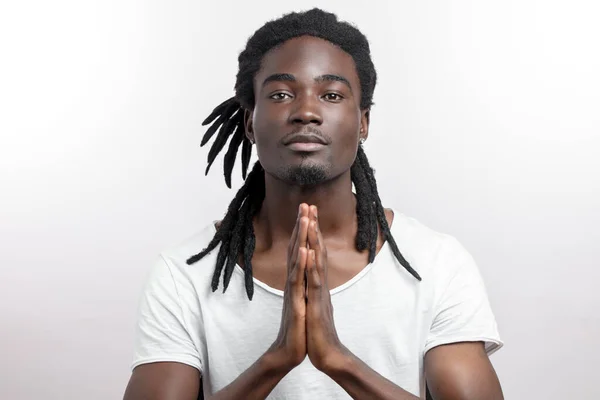 Close up of black man with dreadlocks praying on white background — Stock Photo, Image