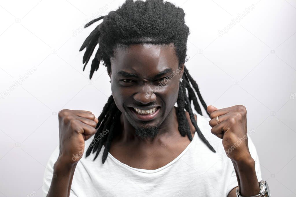 screaming young african man with dreadlocks standing isolated white background. Looking camera.