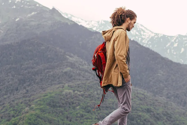 Dağda yürüyen kırmızı sırt çantalı bir gezgin. Seyahat tarzı macera tatili özgürlük konsepti — Stok fotoğraf