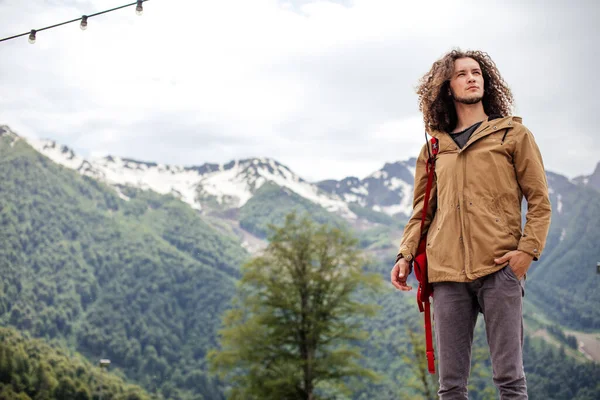 Man Traveler with red backpack relaxing outdoor with rocky mountains on background — Stock Photo, Image