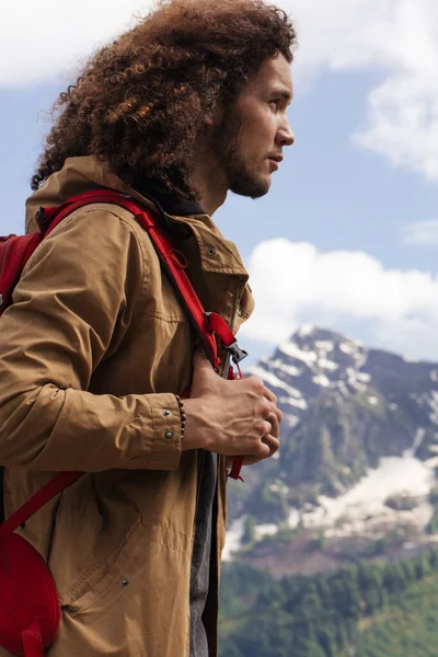 Man Traveler z czerwonym plecakiem relaks na świeżym powietrzu z góry skaliste na tle — Zdjęcie stockowe