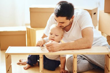 Baba ve oğul evde mobilya topluyor.