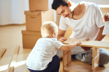 Baba ve oğul evde mobilya topluyor.