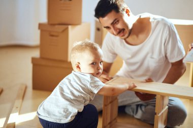 Baba ve oğul evde mobilya topluyor.