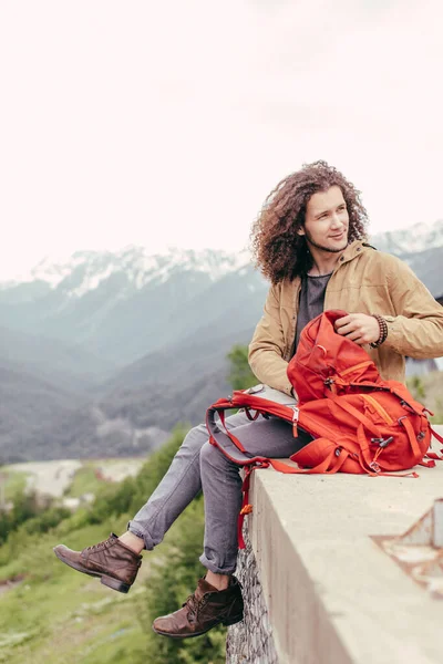 Adam, arka planda dağlar olan yürüyüş için sırt çantası hazırlıyor — Stok fotoğraf