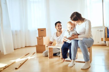 Aile içi okuma talimatları ve mobilyaları yeni taşınan kutuların taşındığı oturma odasında bir araya getirmek