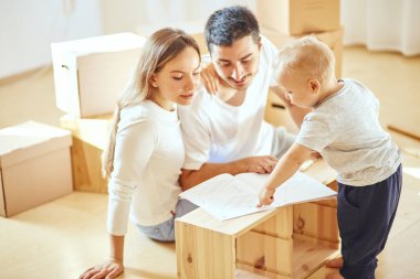 Aile içi okuma talimatları ve mobilyaları yeni taşınan kutuların taşındığı oturma odasında bir araya getirmek