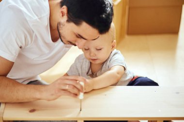 Baba ve oğul evde mobilya topluyor.