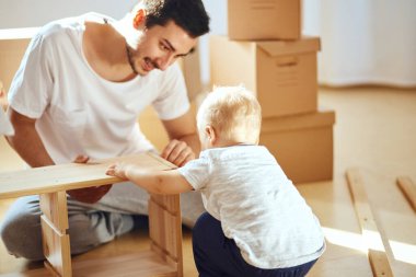 Baba ve oğul evde mobilya topluyor.