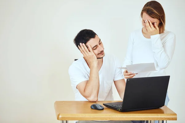 Ongelukkig paar met rekeningen en laptop thuis, belasting betalen — Stockfoto