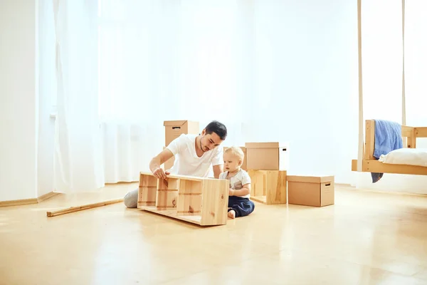 Pai e filho montando móveis em casa — Fotografia de Stock