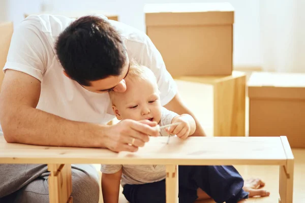 Far och son monterar möbler hemma — Stockfoto