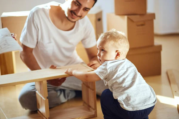 Pai e filho montando móveis em casa — Fotografia de Stock
