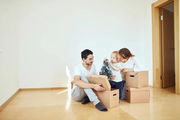 Familia con niño desempacando cajas de cartón móviles en un nuevo hogar —  Fotos de Stock