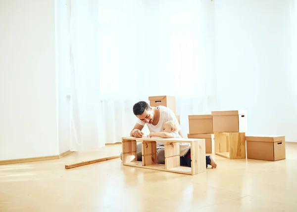 Pai e filho montando móveis em casa — Fotografia de Stock