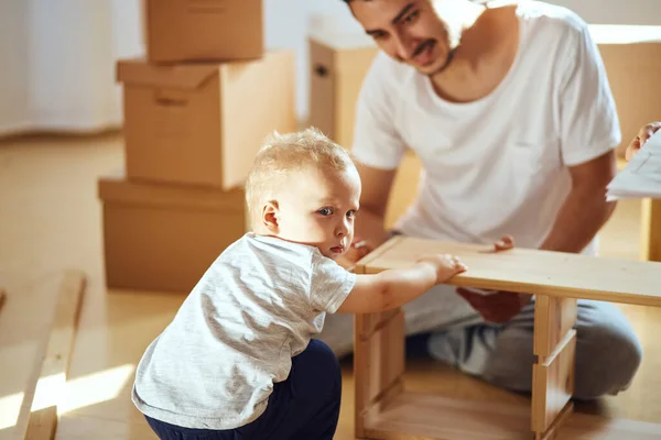 Pai e filho montando móveis em casa — Fotografia de Stock