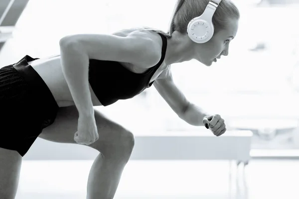 Jong blond running vrouw met oortjes op de rails — Stockfoto
