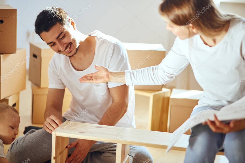 couple installing furniture in new house with instruction