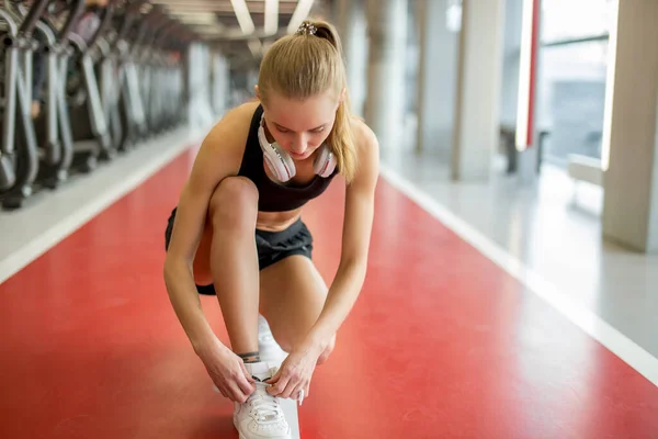 Fille attacher des lacets à la salle de fitness avant de courir exercice d'entraînement pour cardio — Photo