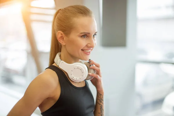 Mujer con el pelo rubio de pie en el club de salud. hermosa mujer fitness en el gimnasio. — Foto de Stock