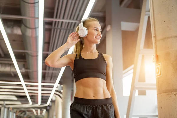 Sport és zene. nő tartsa fülhallgató edzés közben a tornaterem — Stock Fotó