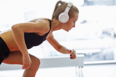 Genç sarışın, koşan, kulaklıklı bir kadın.