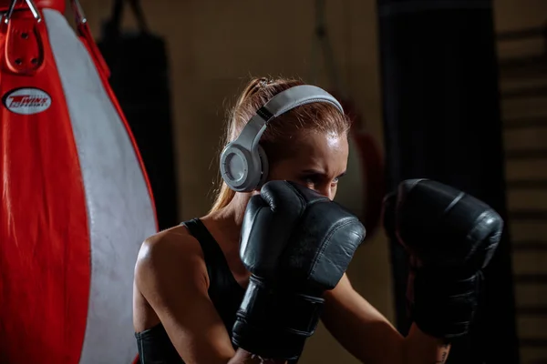 Boxeador femenino en guantes de pie en pose de defensa y mirando enfocado un lado — Foto de Stock