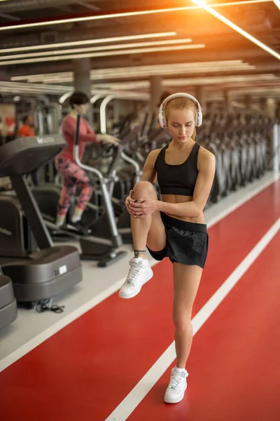 Mujer sana haciendo ejercicio de calentamiento. Ajuste de la mujer de pie en pista roja — Foto de Stock