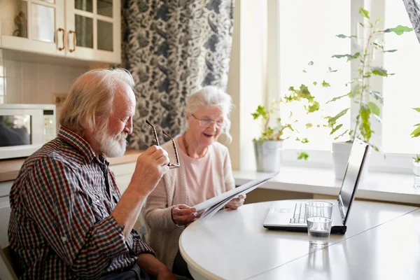 Leende mogna par med dokument och laptop i heminredning — Stockfoto